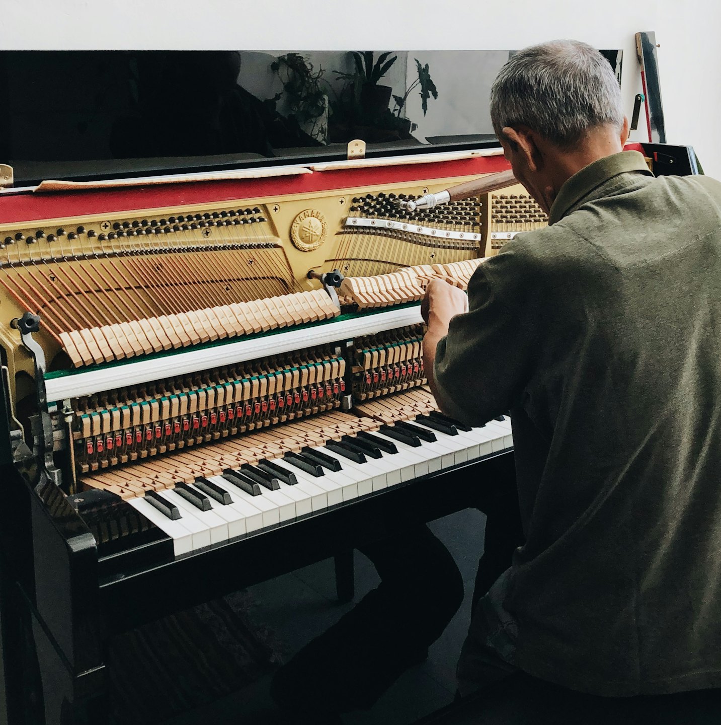 Pianotehnik parandab püstklaveri sisemisi keeli.